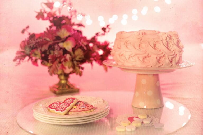 A beautifully decorated pink rose cake with matching floral arrangement, perfect for romantic celebrations.