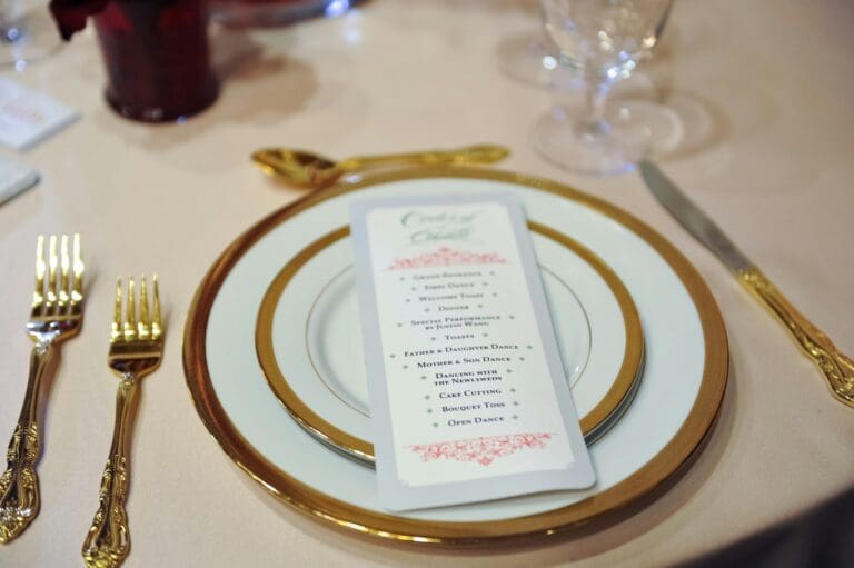 Wedding ceremony program on a plate at reception table, illustrating printed programs and elegant stationery