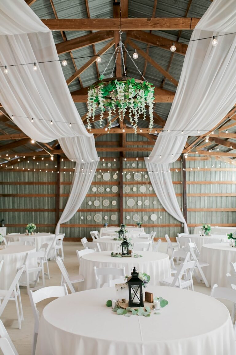 Rustic barn wedding venue decorated with string lights and draped fabric, representing a charming setting for couples