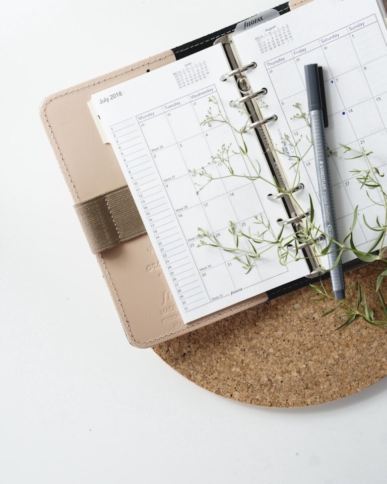 Wedding planning calendar with pen and greenery, representing planning a timeline