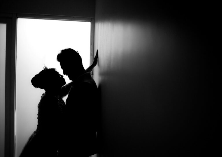 Silhouette of a bride and groom in romantic embrace, illustrating relaxed wedding photography posing tips