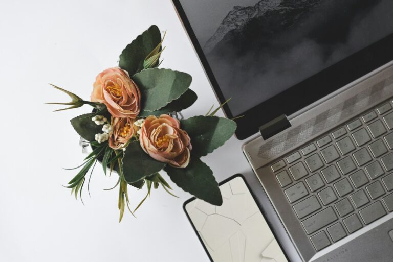 Laptop with a bouquet of roses on the keyboard, illustrating stylish wedding website planning