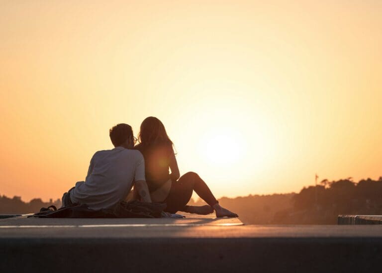Engaged couple relaxing together during golden hour, illustrating premarital counseling and connection
