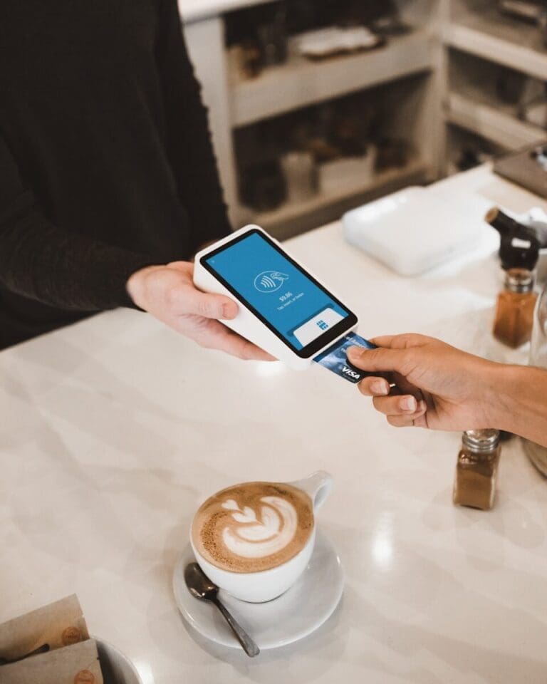 A person inserting a credit card into a payment terminal held by another person